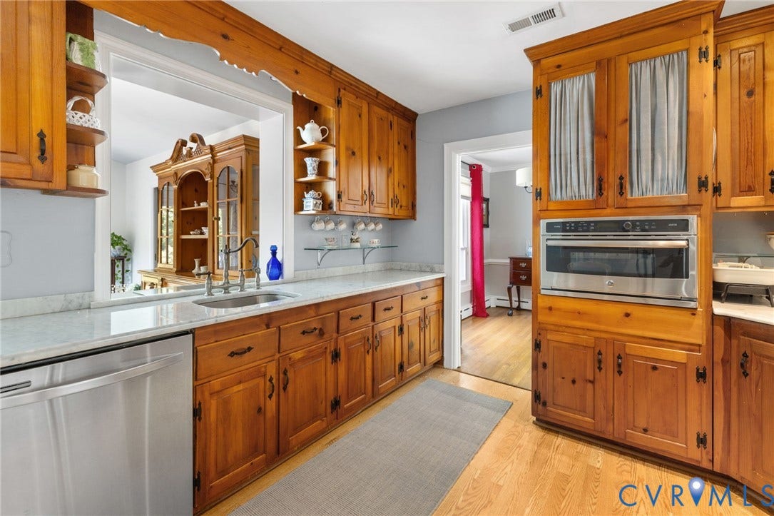 8208 Michael Road, Henrico, VA 23229 Wood cabinetry with dark hardware, undermount sink, stainless steel dishwasher, built-in microwave, and light-toned countertops