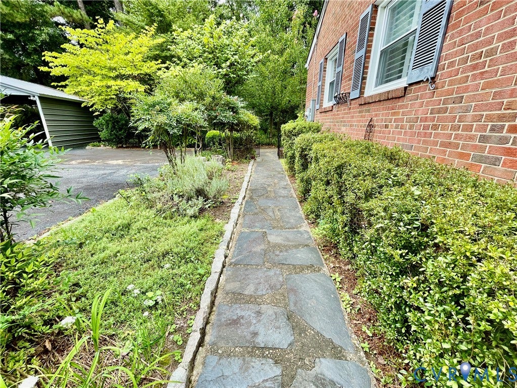 8208 Michael Road, Henrico, VA 23229 Brick exterior with window shutters, flagstone pathway, established shrubbery, and mature trees