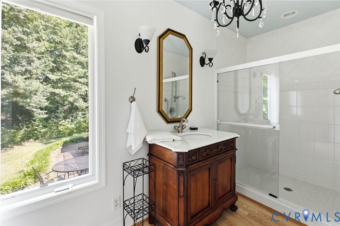 8208 Michael Road, Henrico, VA 23229 Bathroom featuring a carved wood vanity with a white countertop, a frameless glass shower enclosure, and a decorative chandelier