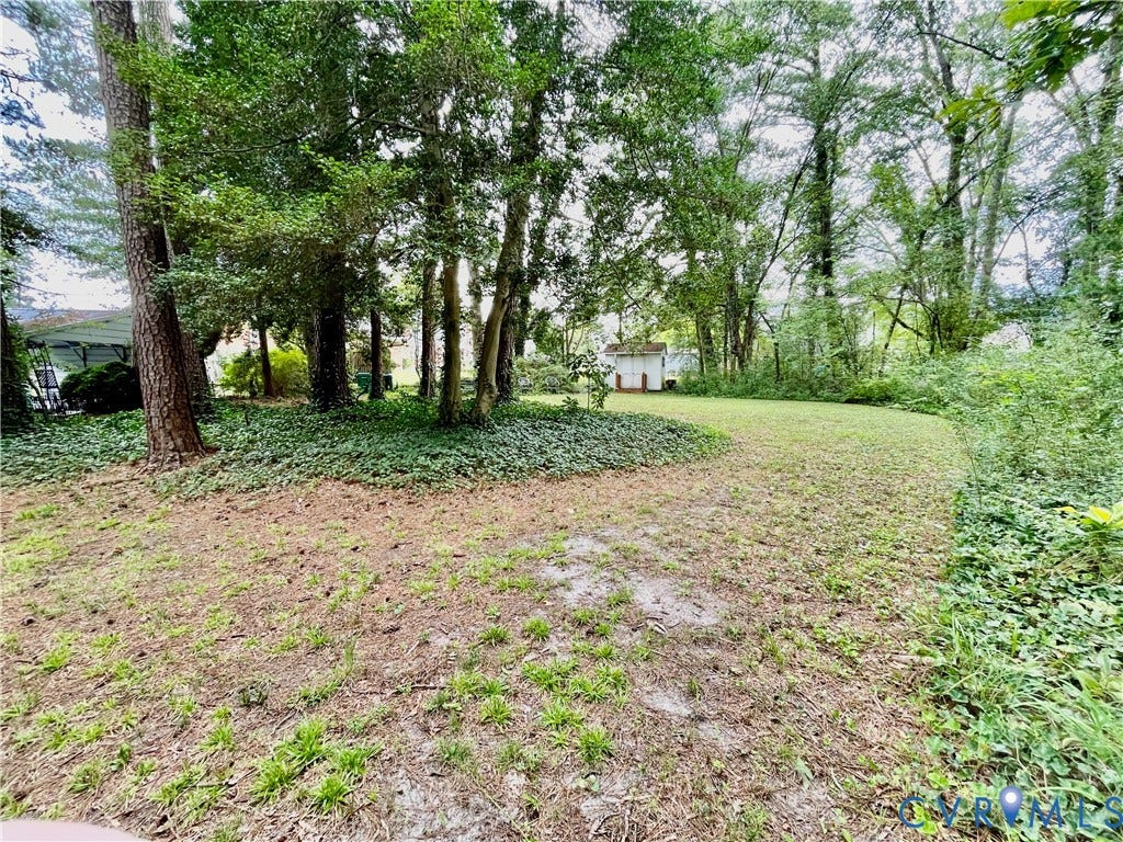 8208 Michael Road, Henrico, VA 23229 Expansive yard featuring mature trees, ground cover, and a detached storage shed