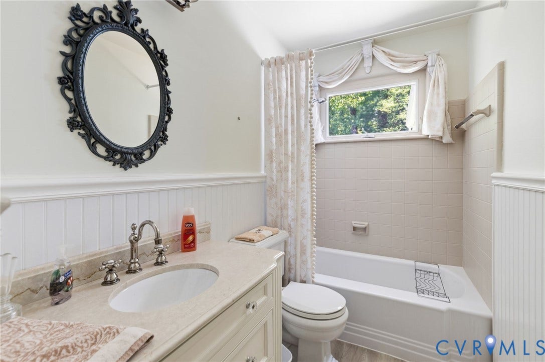 8208 Michael Road, Henrico, VA 23229 White beadboard wainscoting, solid surface countertop, undermount sink, classic brushed nickel faucet, and a tiled shower/tub combination