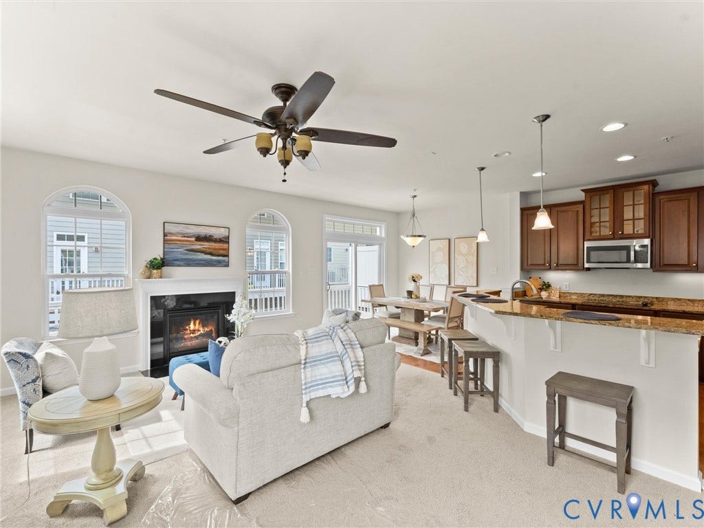 1901 Liesfeld Parkway, West Broad Village, Glen Allen, VA 23060 Open-concept living space featuring a fireplace with a white mantel, arched windows, and a ceiling fan