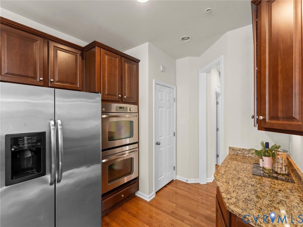 1901 Liesfeld Parkway, West Broad Village, Glen Allen, VA 23060 Stainless steel side-by-side refrigerator, double wall ovens, wood-finish flooring, rich wood cabinetry, and speckled countertops