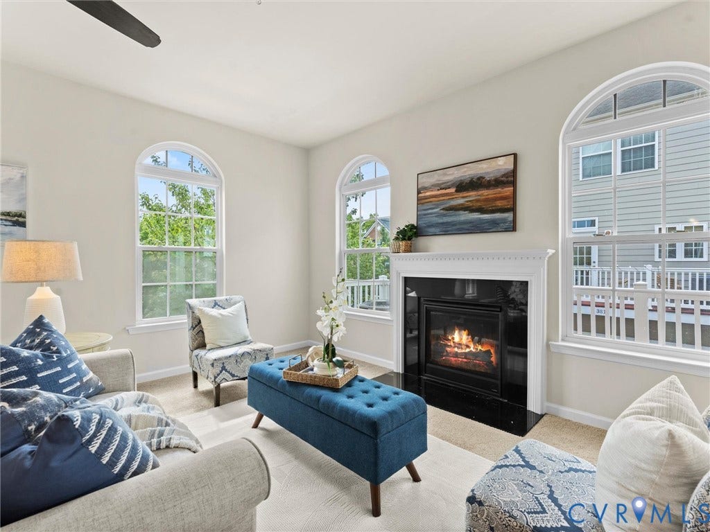 1901 Liesfeld Parkway, West Broad Village, Glen Allen, VA 23060 Arched windows providing ample natural light, a ceiling fan, a fireplace with a black surround and white mantel, and neutral-toned carpeting