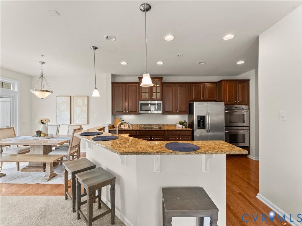 1901 Liesfeld Parkway, West Broad Village, Glen Allen, VA 23060 Kitchen featuring rich wood cabinetry, stainless steel appliances, granite countertops, a breakfast bar, and wood-finish flooring