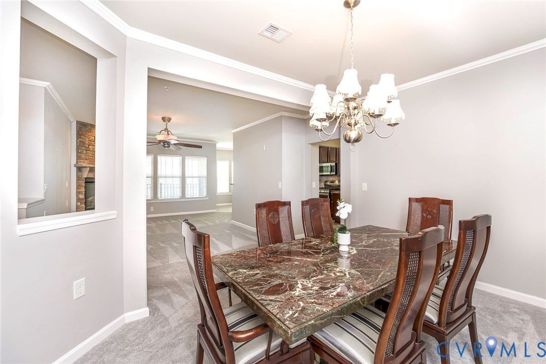 Formal dining room w/decorative chandelier and crown molding.Flows beautiffuly into living room