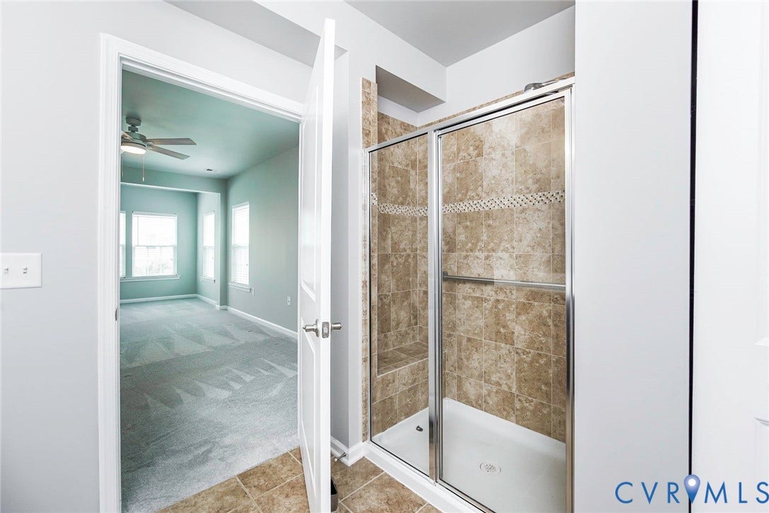 Tiled walk-in shower with a glass enclosure and built-in bench