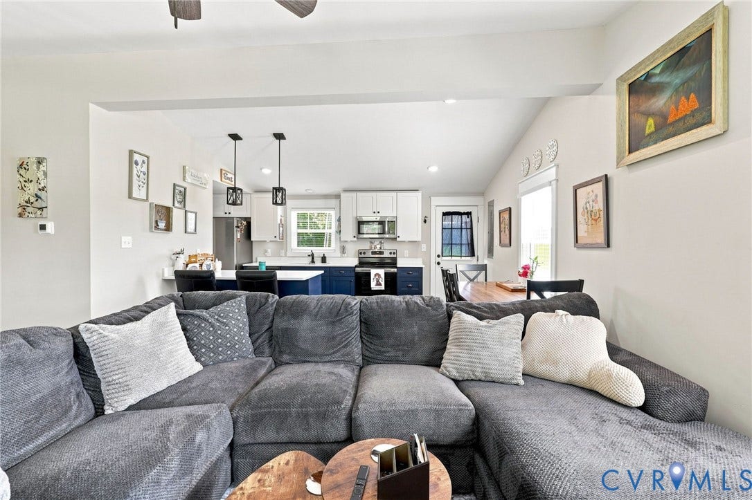1108 Schroeder Road, Powhatan, VA 23139 Open-concept living area with vaulted ceilings, featuring a kitchen with dual-tone cabinetry, pendant lighting, and stainless steel appliances