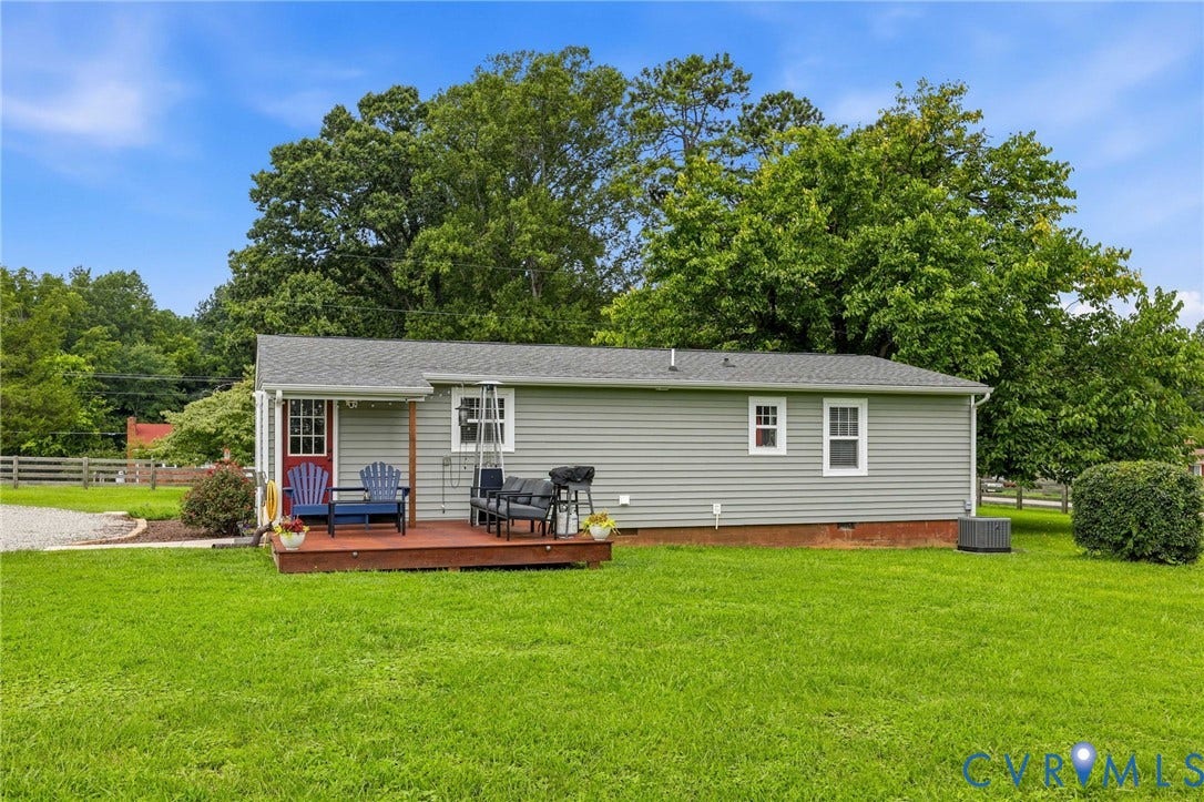1108 Schroeder Road, Powhatan, VA 23139 Grey horizontal siding, wood deck, red entry door, white trim windows, and a gravel driveway