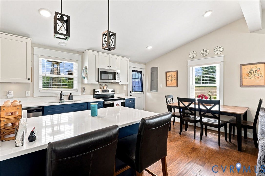 1108 Schroeder Road, Powhatan, VA 23139 Kitchen featuring a central island with countertop seating, stainless steel appliances, pendant lighting, and wood-finish flooring