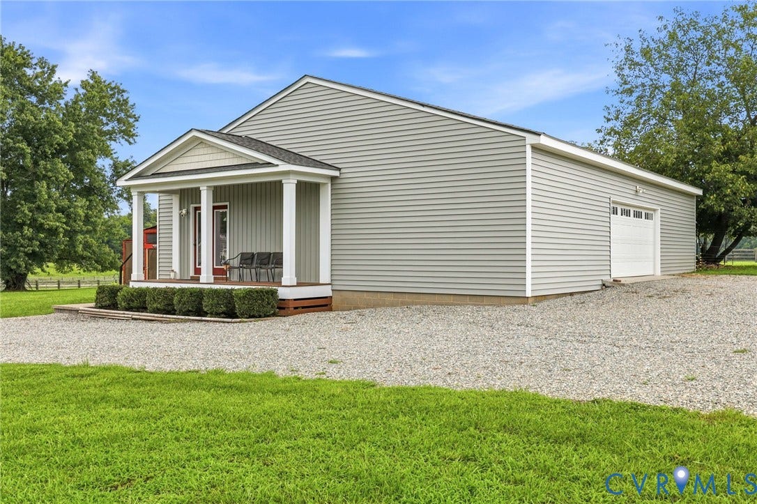 1108 Schroeder Road, Powhatan, VA 23139 Light gray siding exterior with a covered porch, white garage door, and gravel driveway