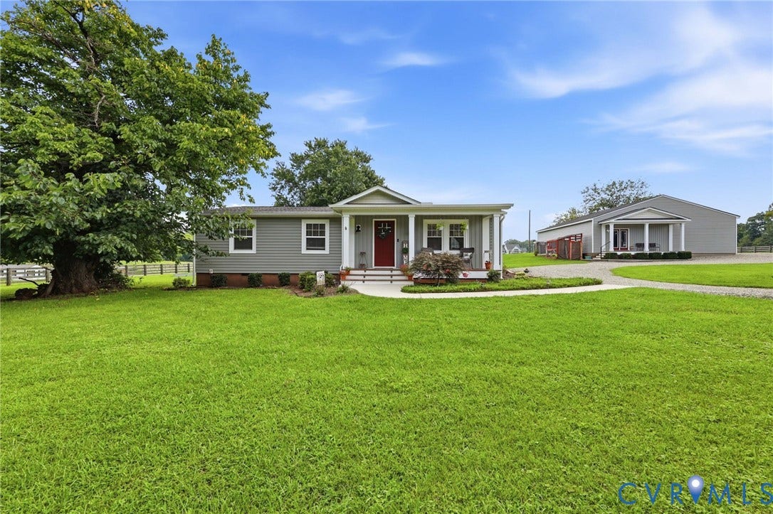1108 Schroeder Road, Powhatan, VA 23139 Gray siding exterior with white trim, covered front porch, red entry door, established tree, and a separate structure with a covered porch