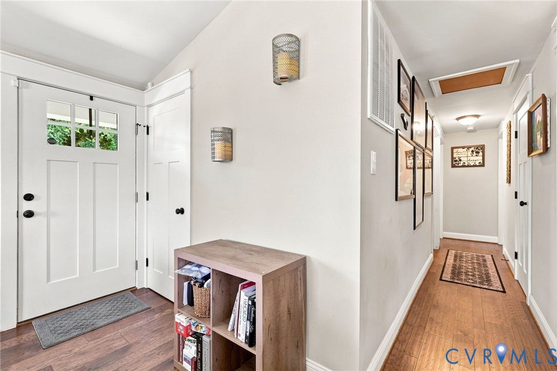 1108 Schroeder Road, Powhatan, VA 23139 Entryway featuring a white paneled door with windowpanes, wood-finish flooring, and two wall-mounted light fixtures