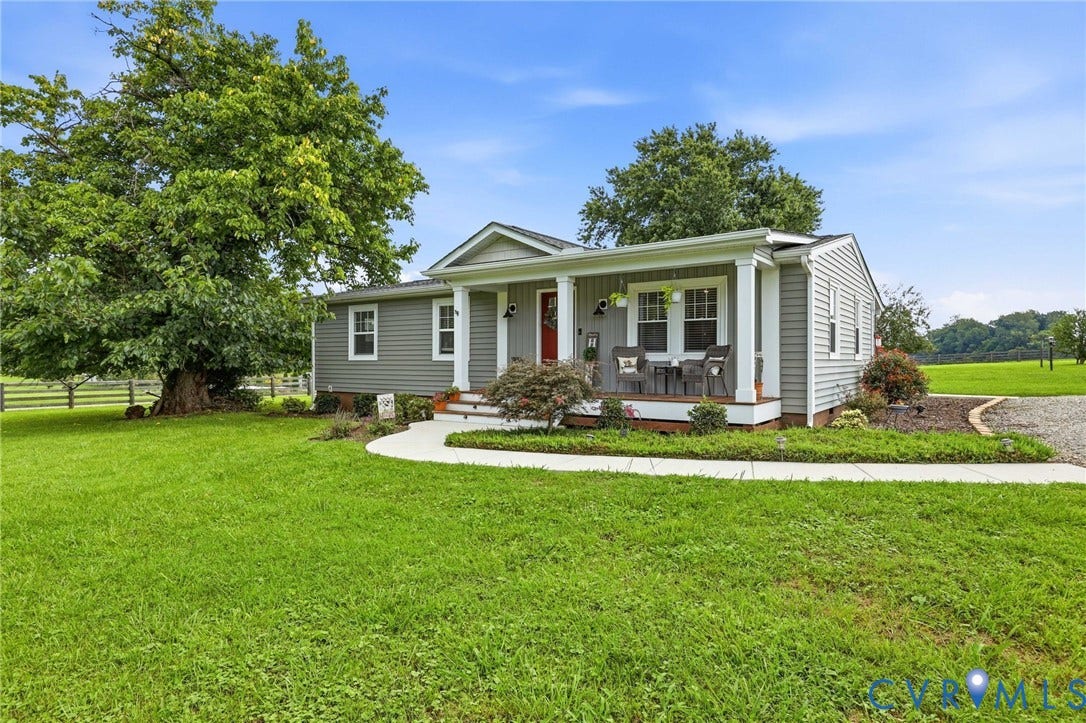 1108 Schroeder Road, Powhatan, VA 23139 Light gray horizontal siding with white trim, covered front porch, concrete walkway, gravel driveway, and a large mature tree