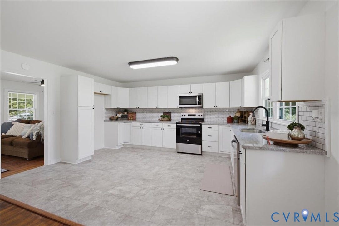 2338 Georges Road, Powhatan, VA 23139 White cabinetry with black hardware, stainless steel appliances, light gray tile flooring, subway tile backsplash, and a black gooseneck faucet