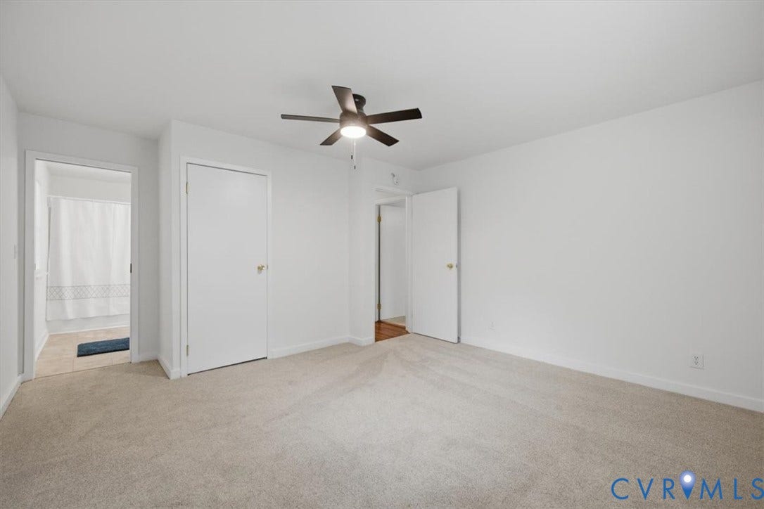 2338 Georges Road, Powhatan, VA 23139 Neutral tone wall paint, light-colored carpet, ceiling fan with integrated lighting, white interior doors, and a bathroom with a shower/tub combination