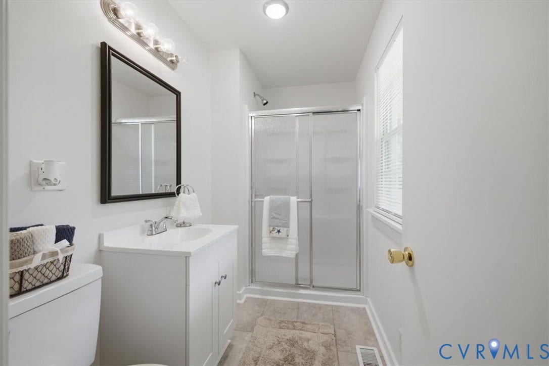 2338 Georges Road, Powhatan, VA 23139 White vanity with integrated sink, chrome faucet, and framed mirror
