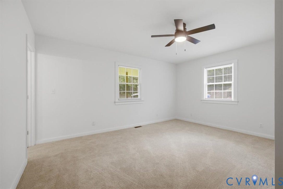 2338 Georges Road, Powhatan, VA 23139 Neutral-toned carpet flooring, two windows with white trim, and a ceiling fan with integrated lighting