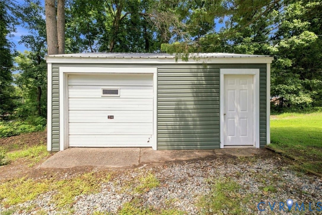 2338 Georges Road, Powhatan, VA 23139 Detached auxiliary structure featuring horizontal siding, a single garage door with an integrated window, a side-entry door, and a metal roof