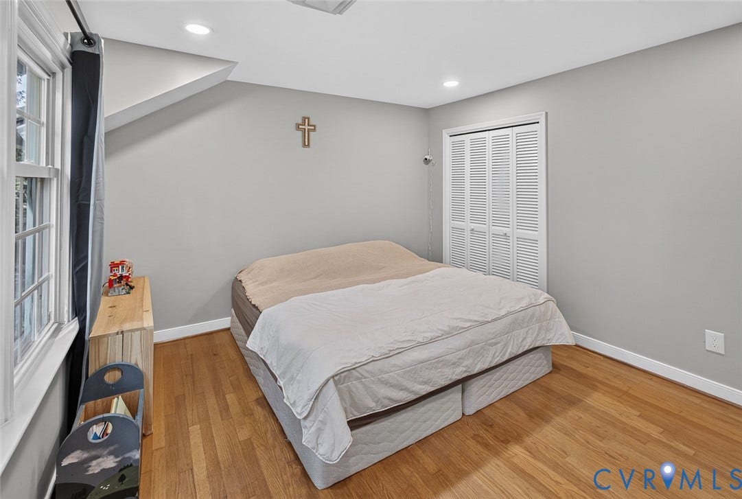 Wood-finish flooring, white louvered bifold closet doors, and recessed ceiling lighting
