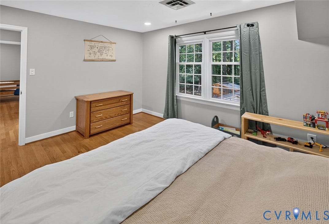 Wood-finish flooring throughout, recessed lighting, and a window with white sashes