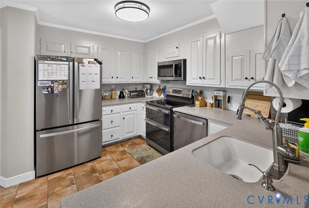 White cabinetry with dark hardware, stone-finish countertops, stainless steel appliances, ceramic tile flooring, and a recessed sink with a high-arc faucet