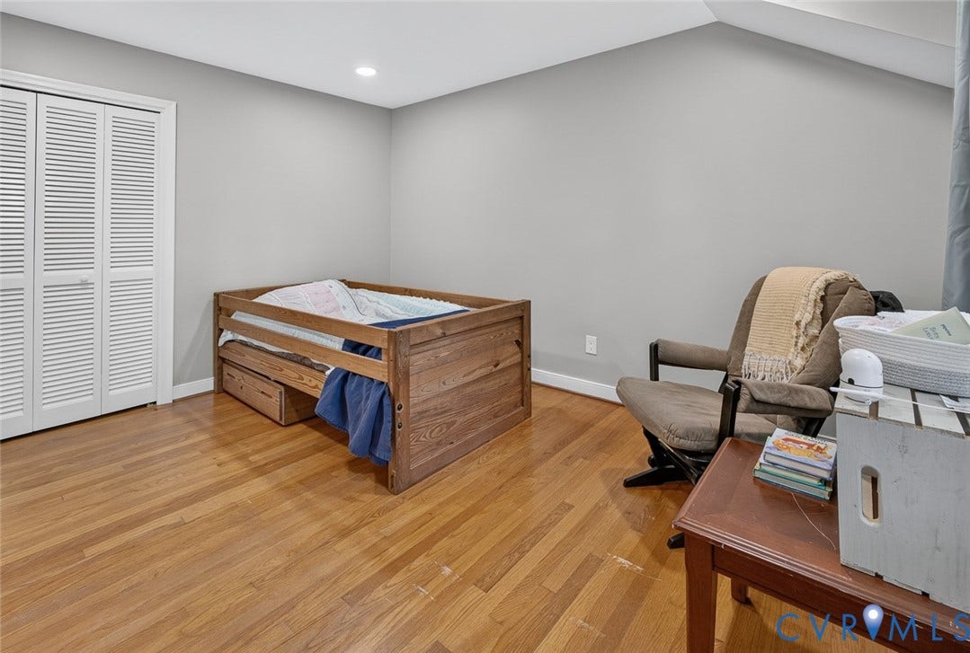 Wood-finish flooring, white louvered bifold closet doors, and recessed ceiling lighting