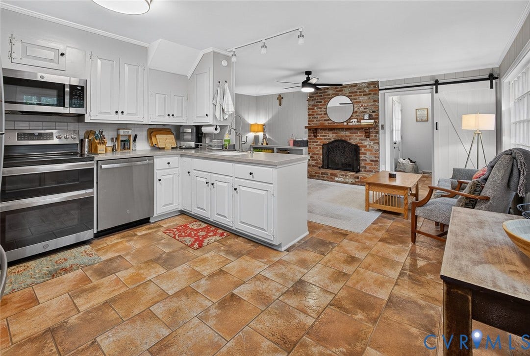 Kitchen featuring stainless steel appliances, white cabinetry, and light-toned countertops