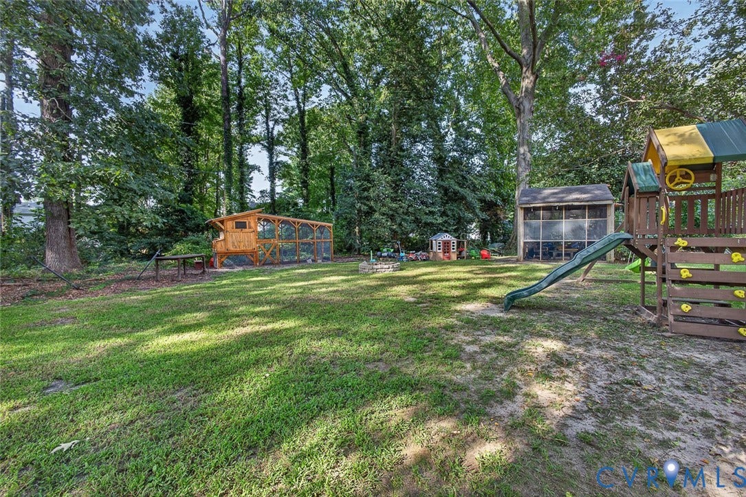 Expansive backyard featuring a chicken coop, a screened-in structure, and mature trees