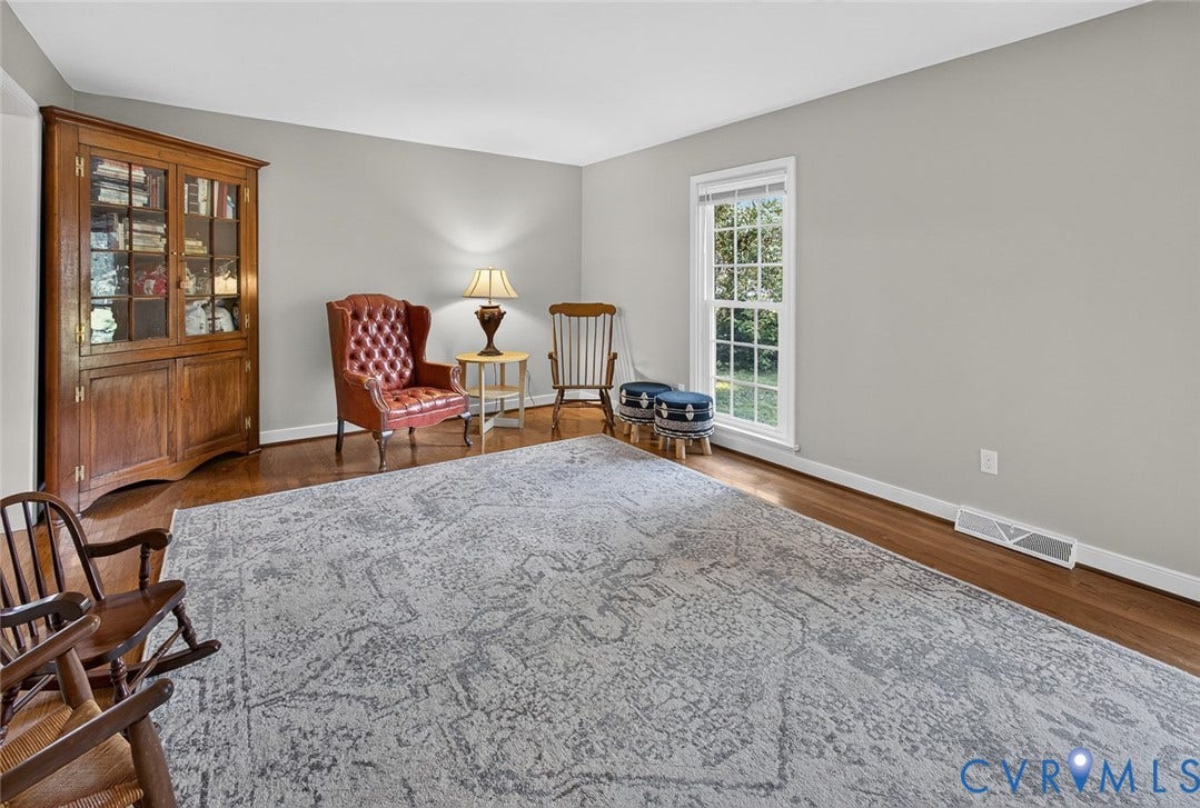 Hardwood flooring throughout, neutral wall tones, and a large window providing ample natural light