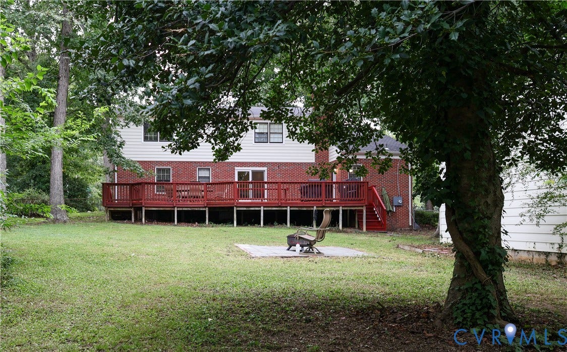 4941 Hopkins Road, Chesterfield, VA 23234 Expansive backyard featuring a large wood deck, brick and siding exterior, and mature trees