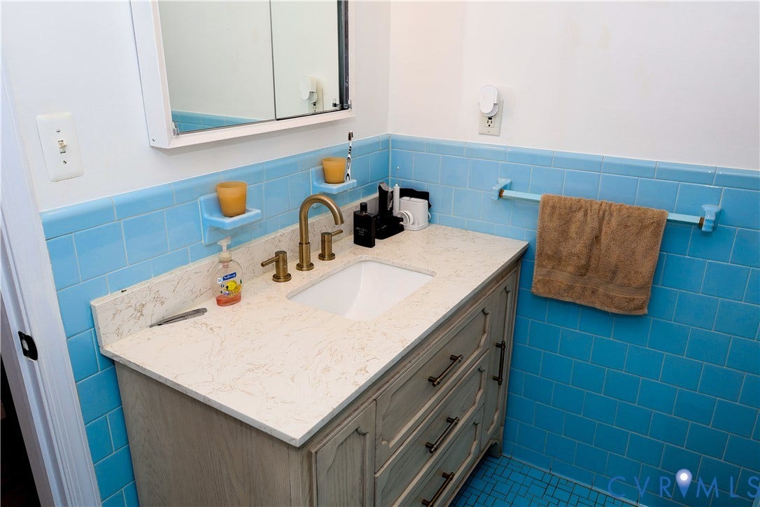 4941 Hopkins Road, Chesterfield, VA 23234 Bathroom vanity with a white countertop and integrated sink, complemented by a gold-finish faucet