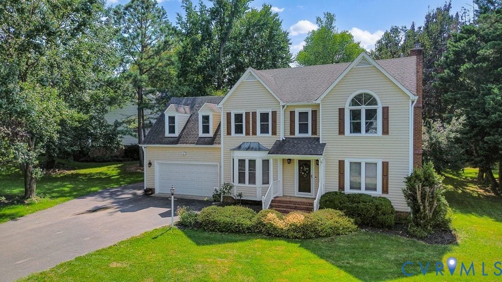 8806 Thornton Heath Drive, Chesterfield, VA 23832 Traditional-style home featuring light-colored siding, a prominent arched window, and a gabled roof