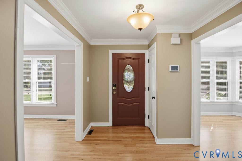 8806 Thornton Heath Drive, Chesterfield, VA 23832 Hardwood flooring, crown molding, a decorative front entry door, and white window blinds