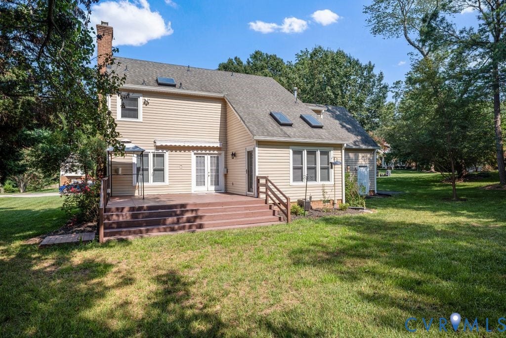 8806 Thornton Heath Drive, Chesterfield, VA 23832 Expansive rear deck with integrated steps, dual French doors, beige siding, multiple skylights, and a brick chimney