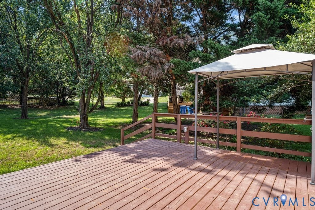 8806 Thornton Heath Drive, Chesterfield, VA 23832 Expansive wood-finish deck with a perimeter railing, overlooking a lush green lawn and mature trees