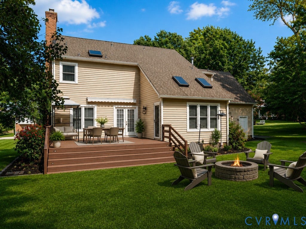 8806 Thornton Heath Drive, Chesterfield, VA 23832 Expansive backyard featuring a multi-level deck, lush lawn, and a built-in stone fire pit
