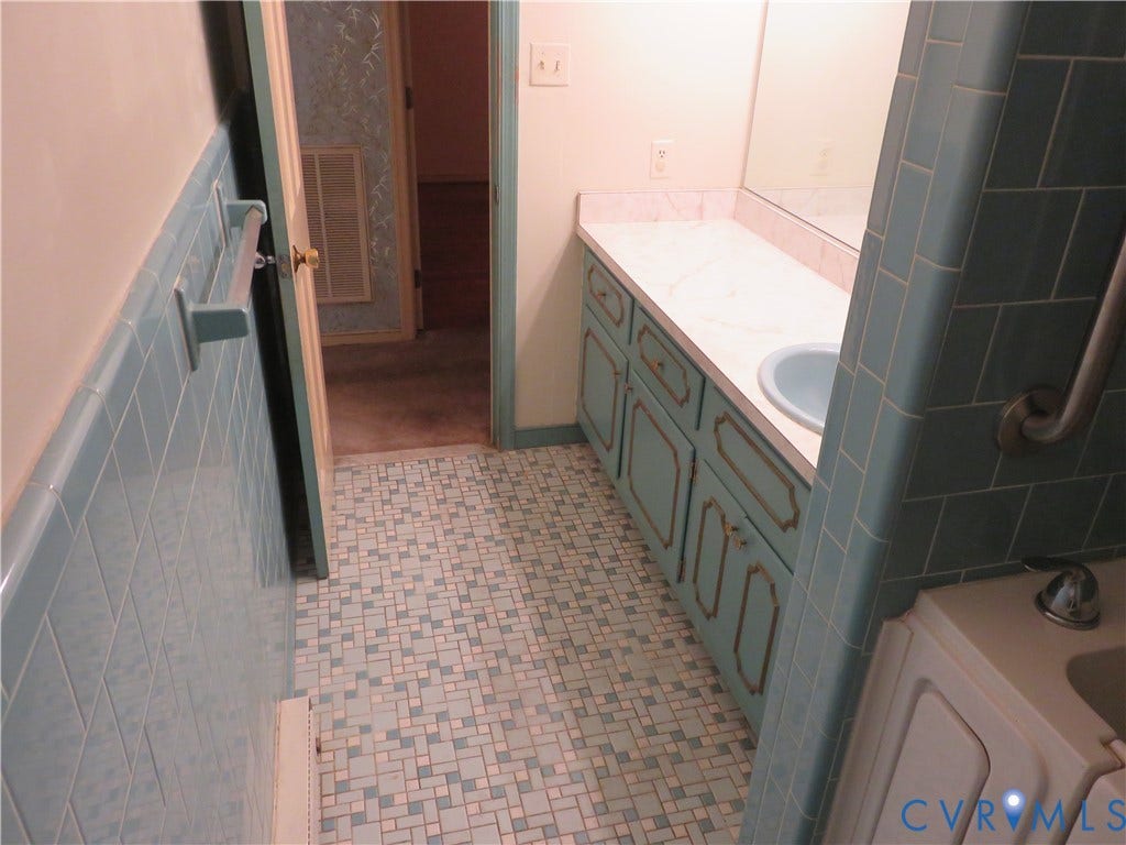 3107 Neale Street, Eastern Henrico, Richmond, VA 23223 Bathroom featuring blue square tile flooring, a built-in vanity with a countertop and integrated sink, and tiled shower walls