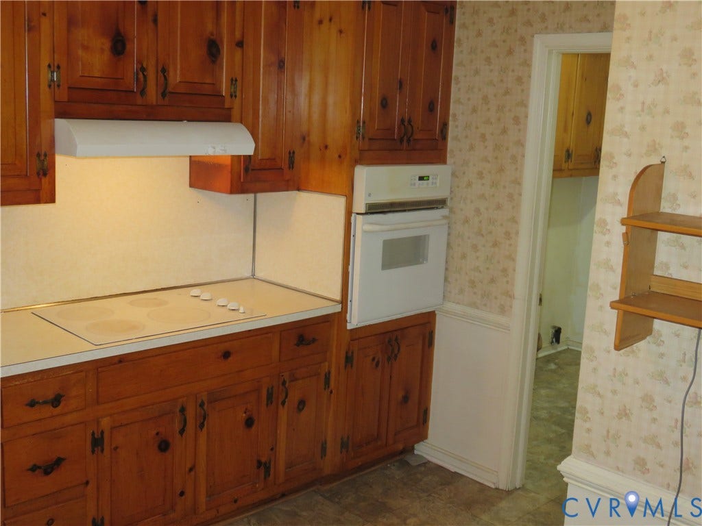 3107 Neale Street, Eastern Henrico, Richmond, VA 23223 Built-in oven, integrated electric cooktop, wood cabinetry, and a range hood