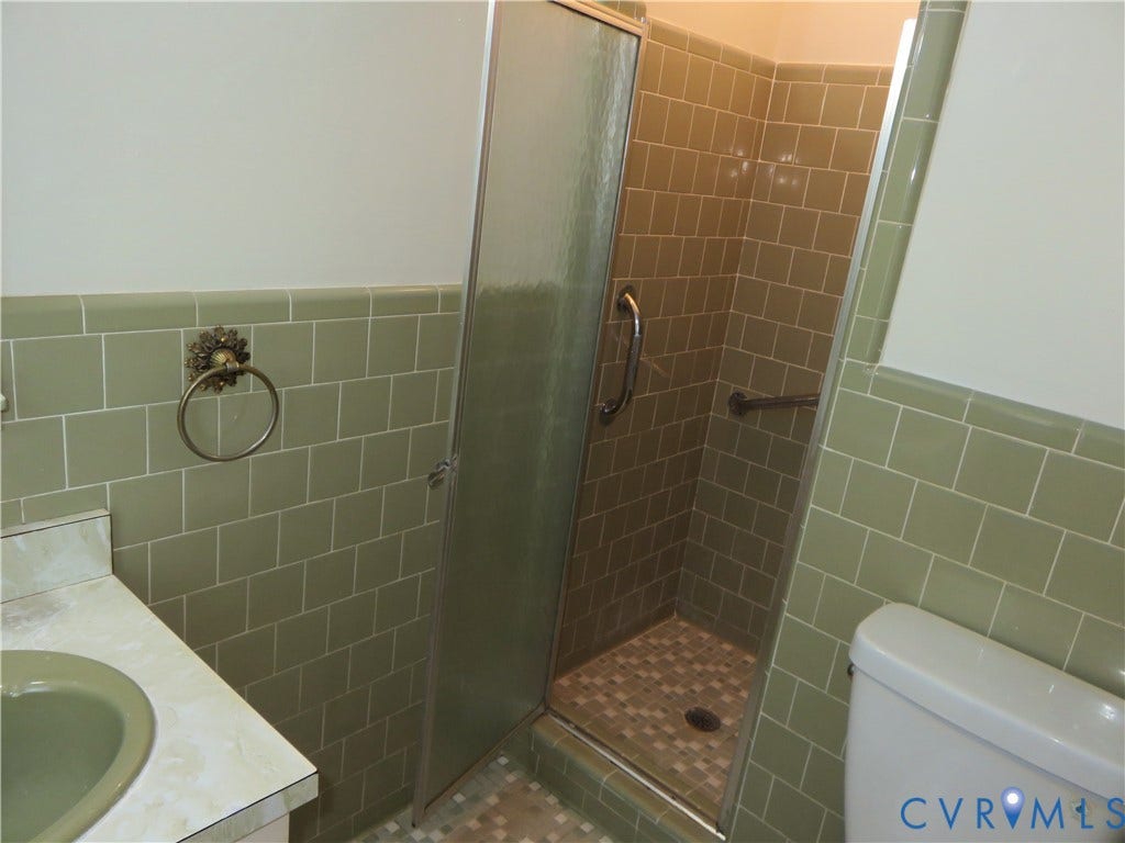 3107 Neale Street, Eastern Henrico, Richmond, VA 23223 Shower enclosure with a clear glass panel door, light green subway tile walls, and a tiled shower floor
