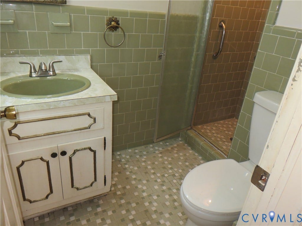 3107 Neale Street, Eastern Henrico, Richmond, VA 23223 Green tiled walls, white vanity with gold-trimmed cabinet doors, built-in sink, glass-enclosed shower, mosaic-tiled flooring