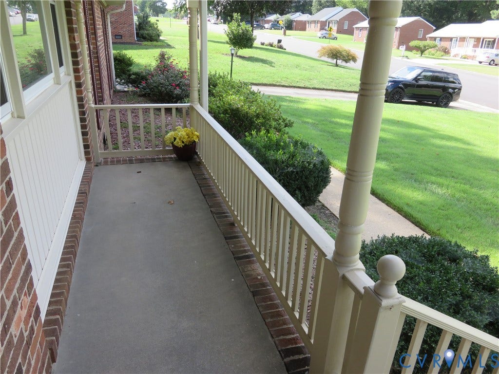 3107 Neale Street, Eastern Henrico, Richmond, VA 23223 Covered front porch with painted railing and balusters, brick exterior, and concrete flooring
