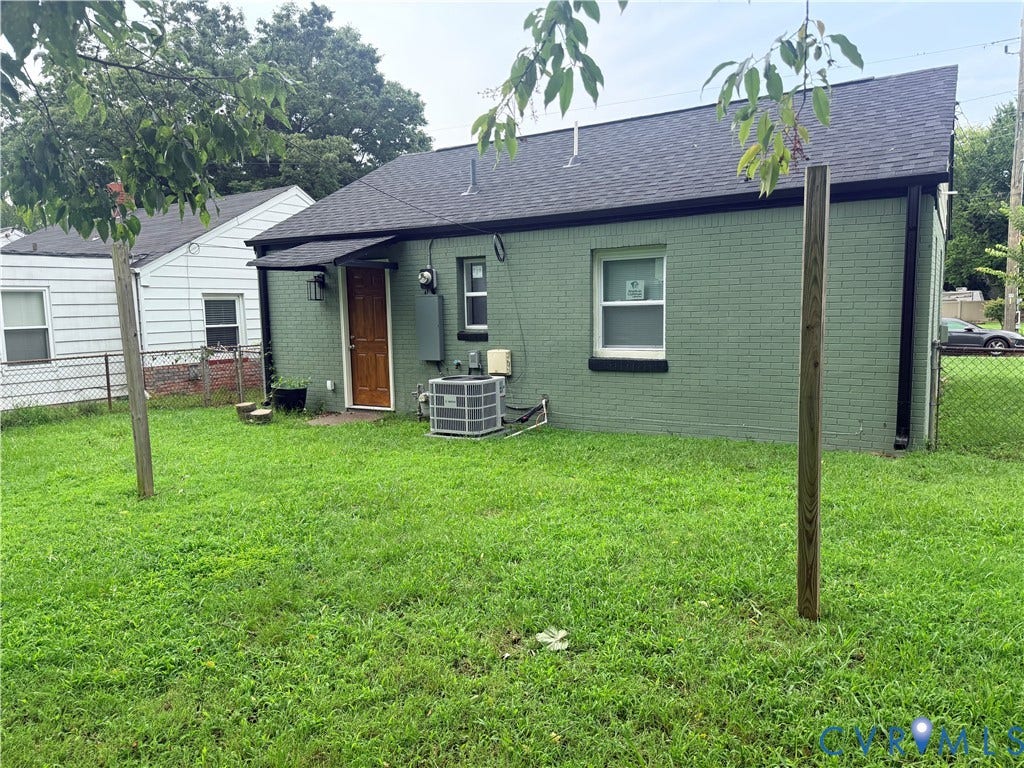 1826 Claiborne Street, Byrd Park, Richmond, VA 23220 Brick exterior with a contemporary green finish, dark asphalt shingle roof, and a wood-paneled rear entry door
