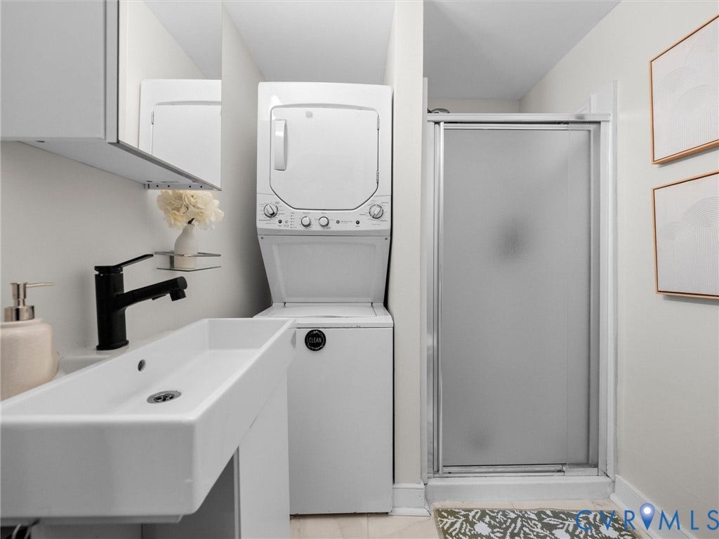 709 Ratcliffe Avenue, Richmond, VA 23222 Rectangular vessel sink with a matte black faucet, white upper cabinetry, and a stacked washer and dryer