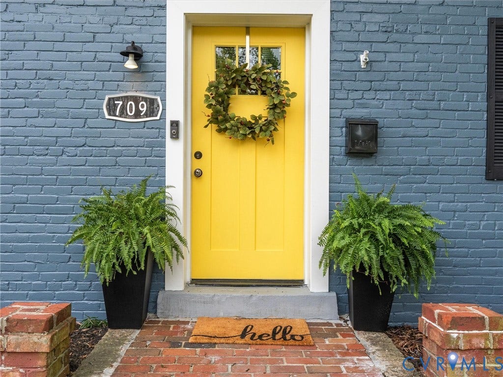 709 Ratcliffe Avenue, Richmond, VA 23222 Painted brick exterior with a yellow paneled door, white trim, and a brick pathway