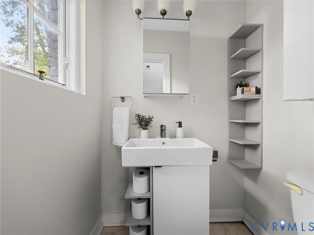 709 Ratcliffe Avenue, Richmond, VA 23222 Pedestal vanity with an integrated rectangular sink, wall-mounted mirror, and built-in corner shelving