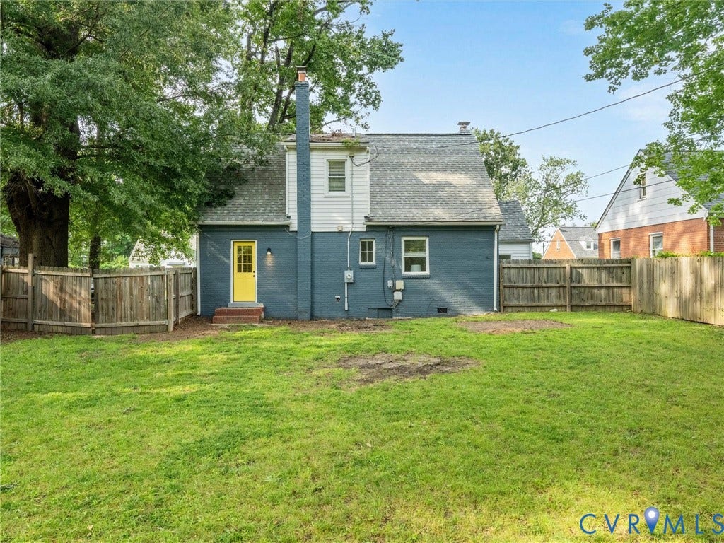 709 Ratcliffe Avenue, Richmond, VA 23222 Expansive rear yard featuring green space, a full privacy fence, and a vibrant yellow rear entry door