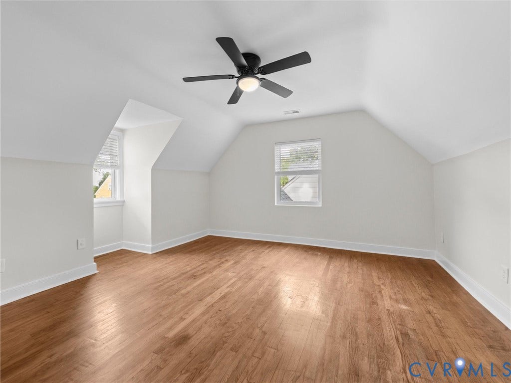 709 Ratcliffe Avenue, Richmond, VA 23222 Spacious room featuring wood-finish flooring, white walls, angled ceilings, and a ceiling fan with integrated lighting