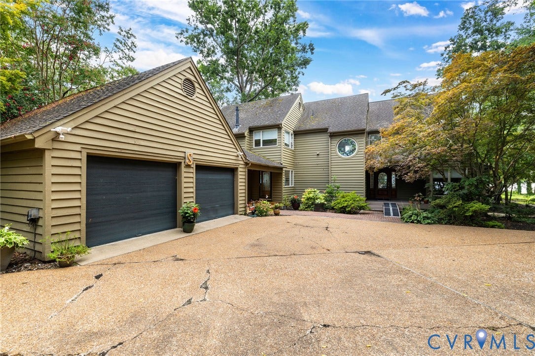 3416 Walkers Ferry Road, Walkers Ferry, Midlothian, VA 23112 Two-car garage with horizontal siding, circular window accent, mature landscaping, and an inviting entry