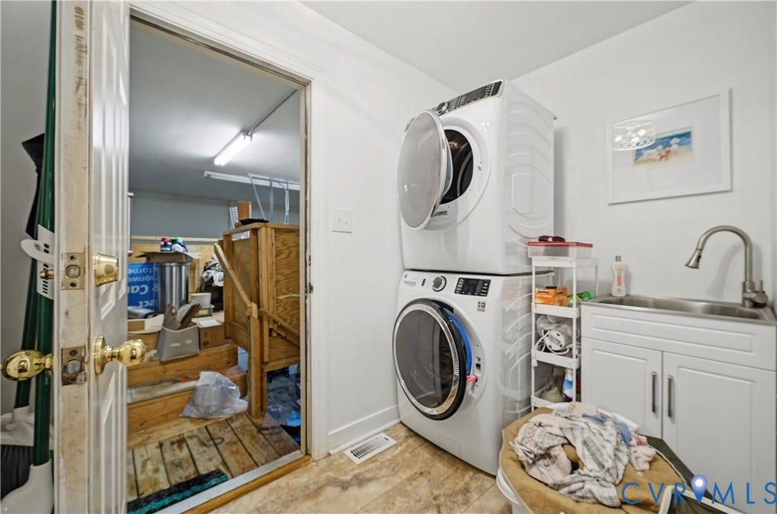 411 Hickory Drive, Manakin Sabot, VA 23103 Stacked washer and dryer, utility sink with stainless steel faucet, white lower cabinetry, and light-toned flooring